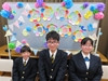 壁面飾りを背に、在舎生が新入舎生をはさんで３名笑顔で並んでいるところ