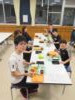 夕食を前に、全員がテーブルについて笑顔をカメラに向けているところ。