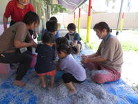 シュレッダーした紙が入っているたらいに水を入れようとしたら、幼児たちが集まってきた。