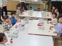 ケーキが配られたテーブルを幼児たちが囲んでいる。
